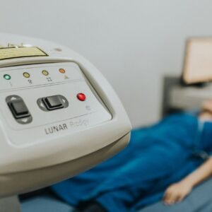 Medical examination setting with patient lying on bed, focus on healthcare device.