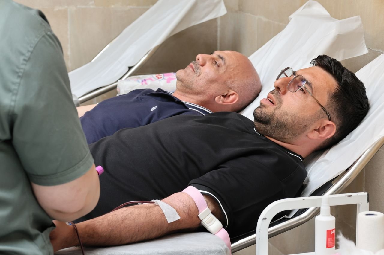 pexels photo 37553374 37553374 Two men are lying on medical beds while donating blood at a clinic.