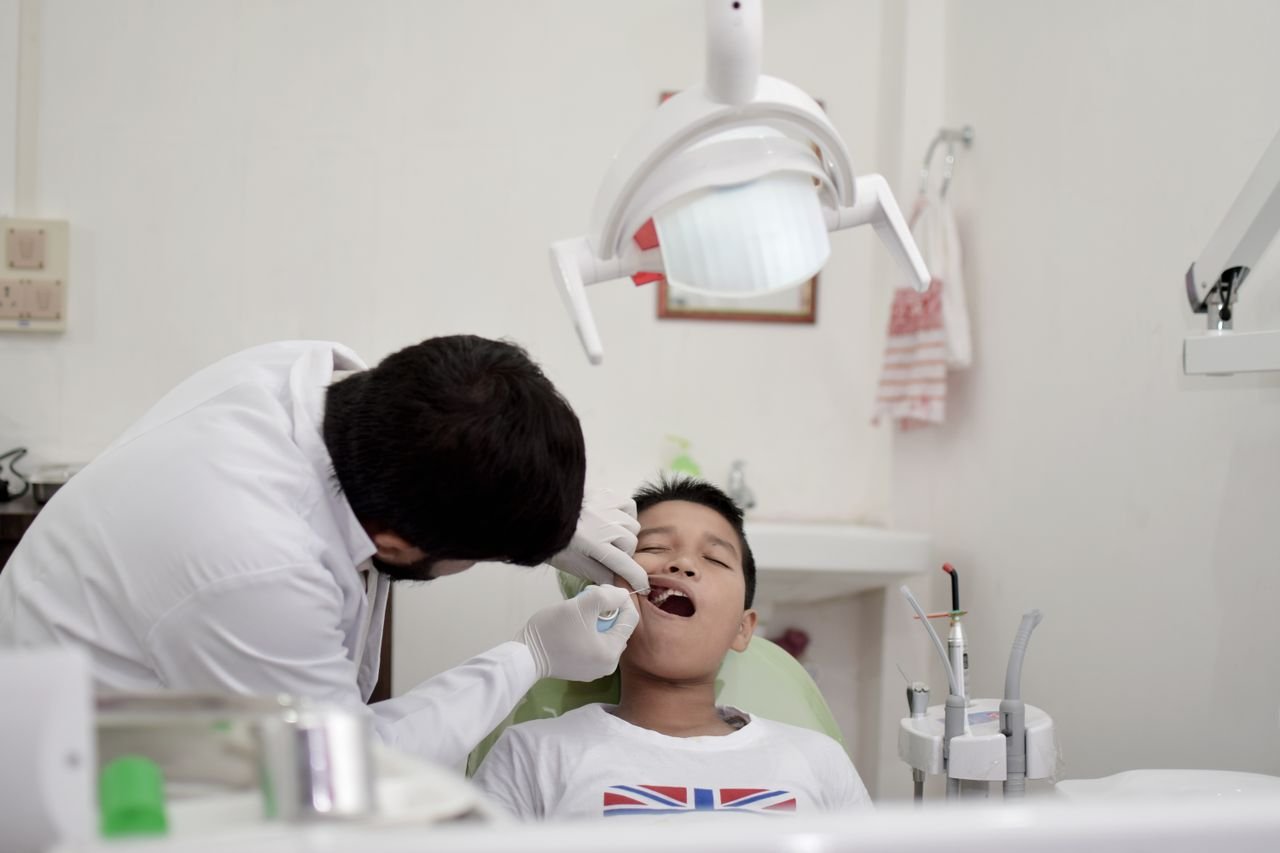 pexels photo 8224659 8224659 A young boy is receiving a dental checkup from a dentist wearing gloves in a clinic.