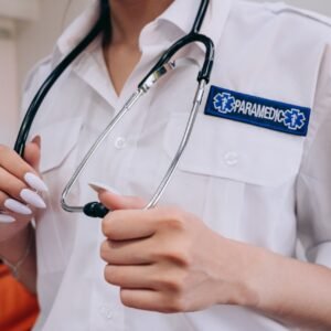 A paramedic in uniform holds a stethoscope, ready for medical assistance.